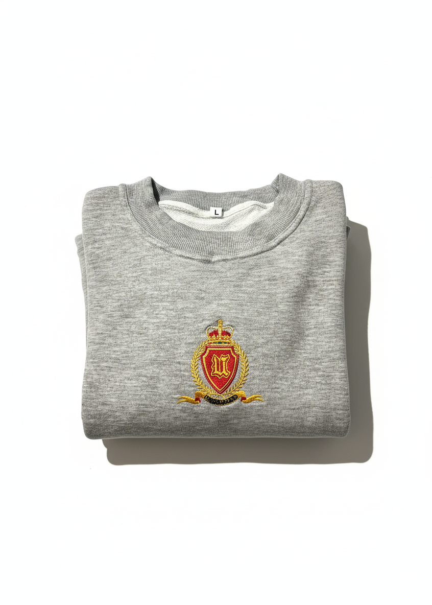 Folded gray sweatshirt with a crest on a white background