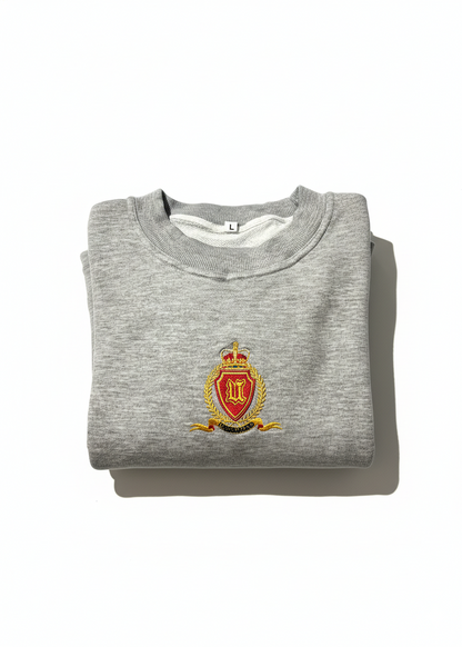Folded gray sweatshirt with a crest on a white background