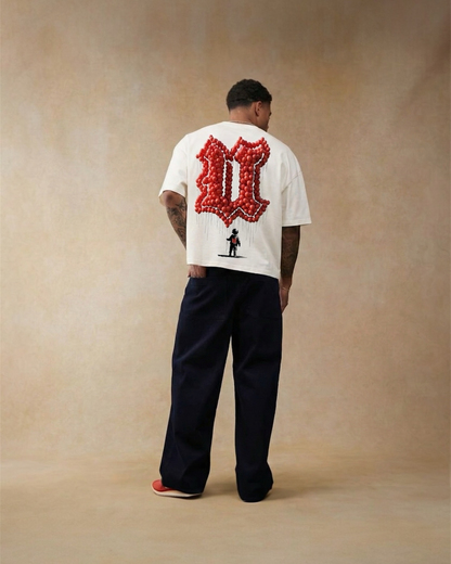 Person wearing a white t-shirt with a red graphic on the back against a beige background