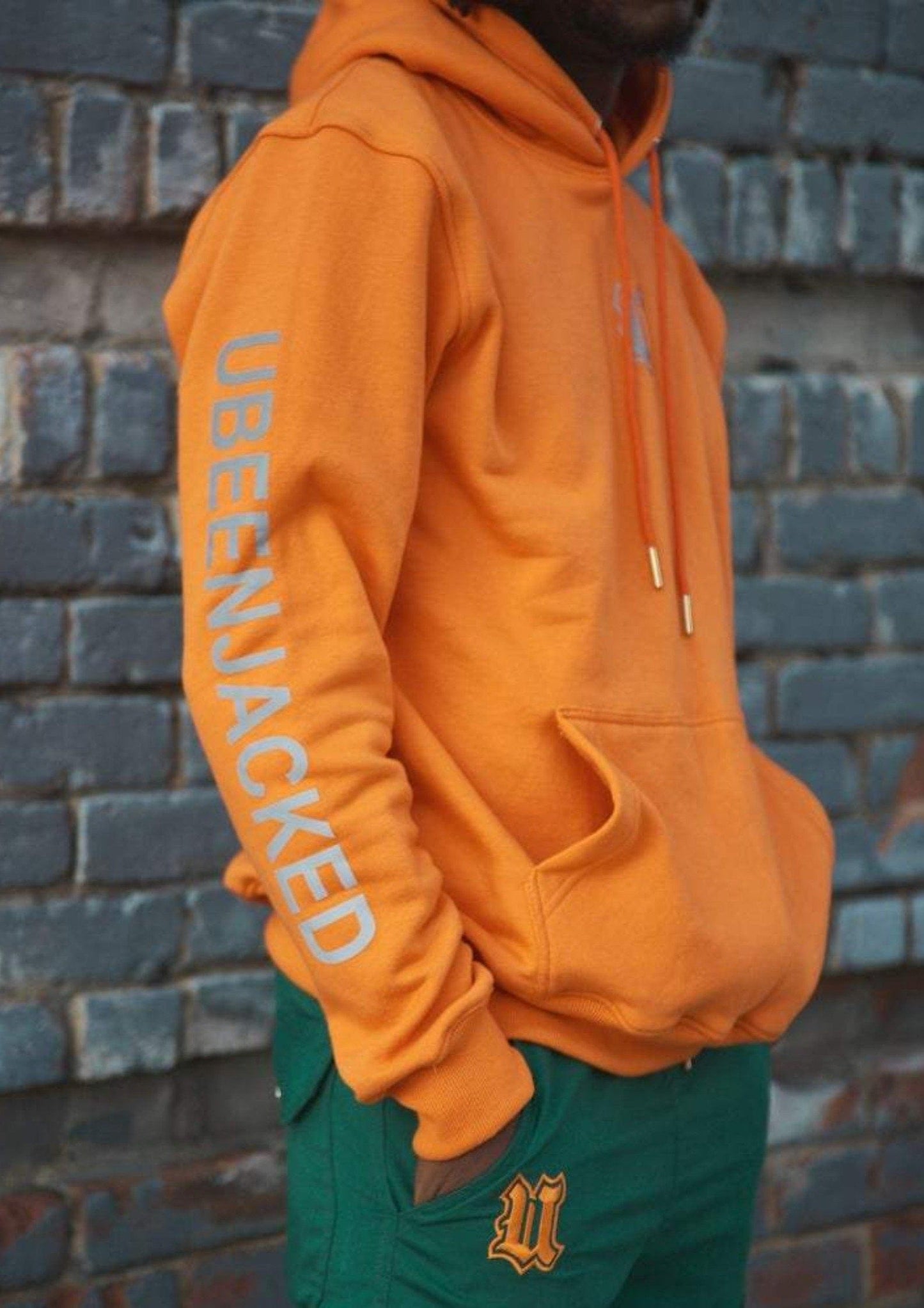 Side View Orange UBJ hoodie with reflective print on the arm